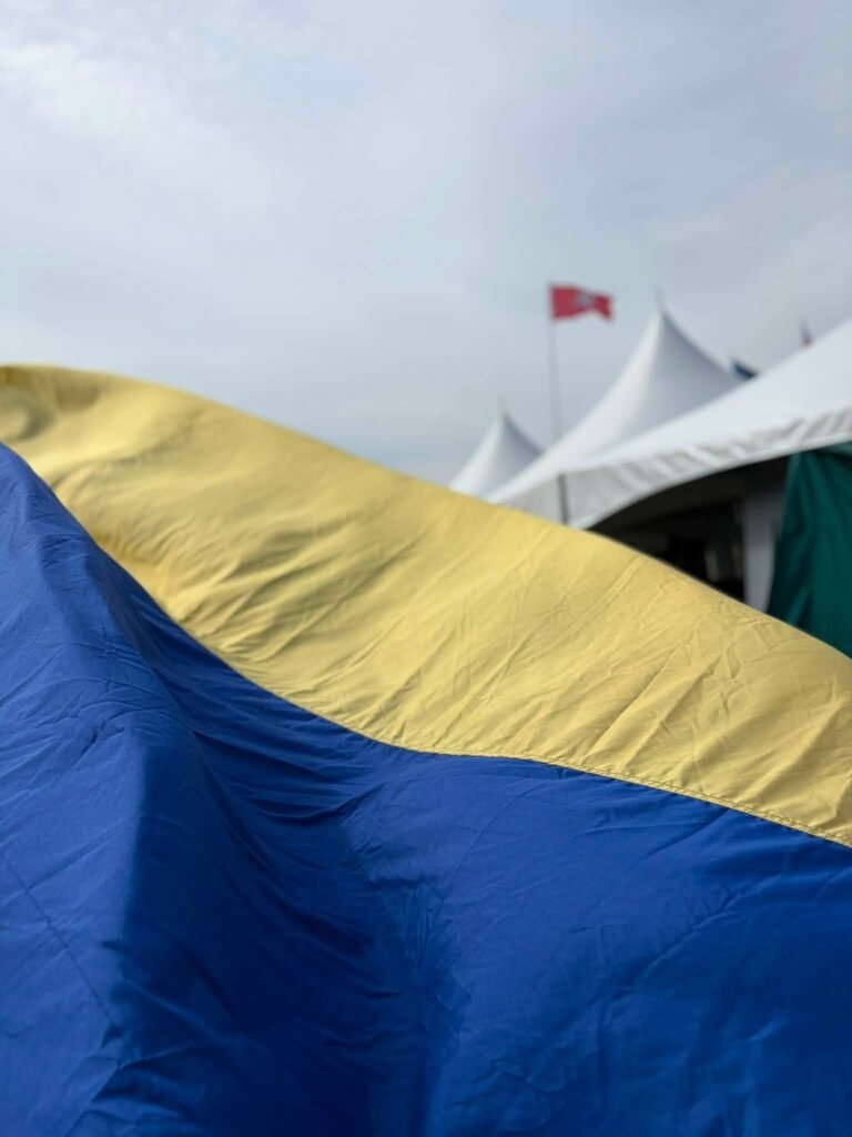 Ukrainos vėliava plevėsuoja pirmame plane, už jos – baltos festivalio „Fort-Unija“ palapinės IV forte